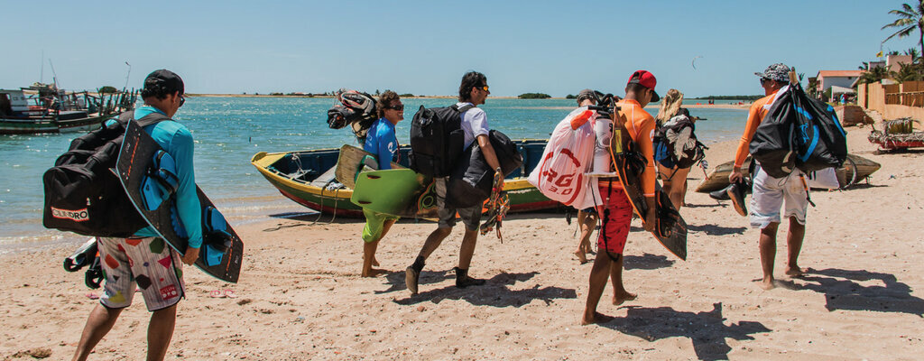 kitesboarders walking on beach